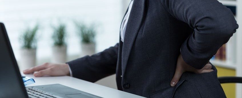 Businesswoman suffering from pain of lower back